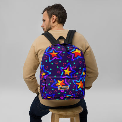Man wearing a colorful star-patterned backpack on a gray background