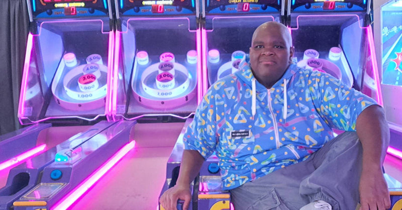 Person sitting in front of a colorful arcade machine