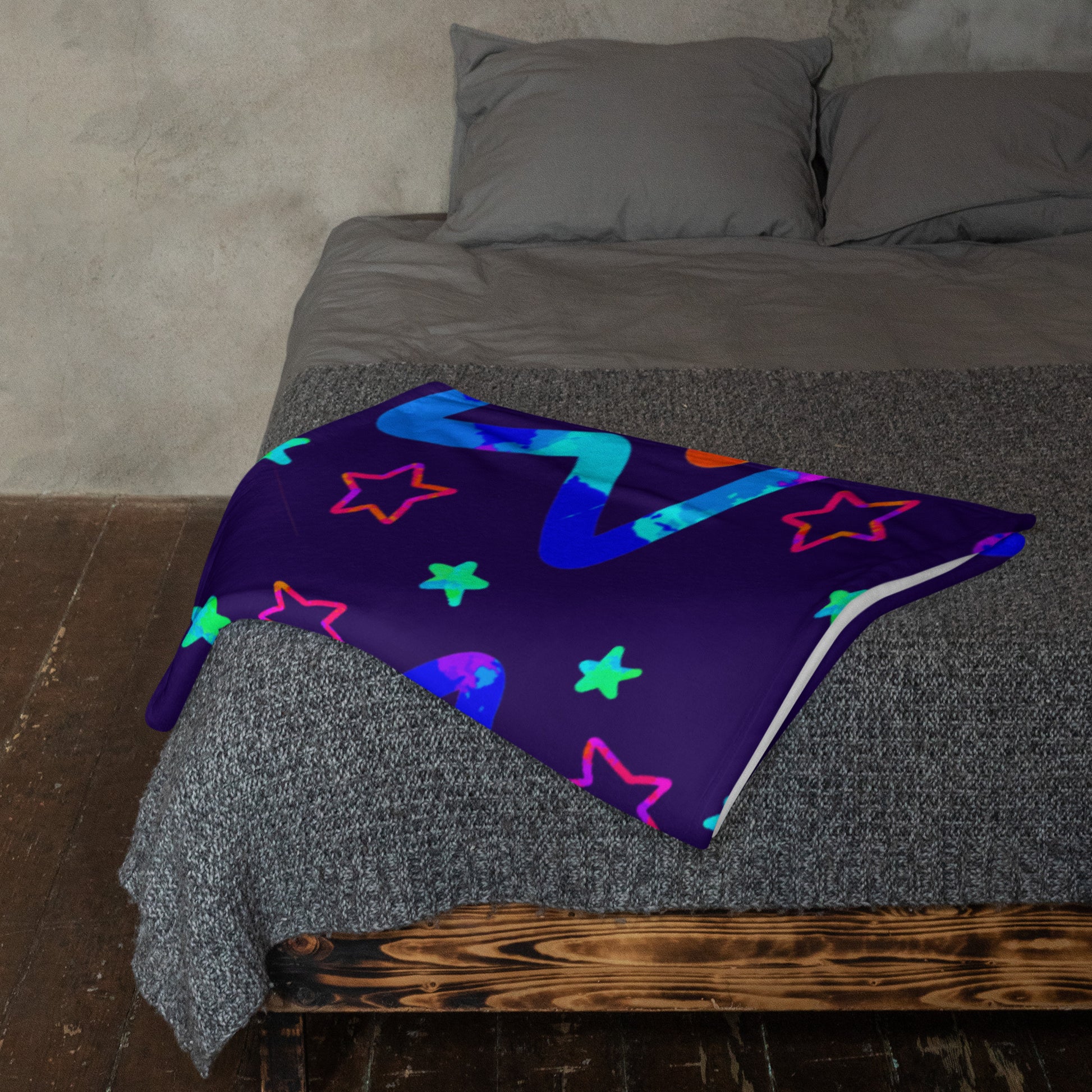Colorful star-patterned blanket on a bed with gray bedding