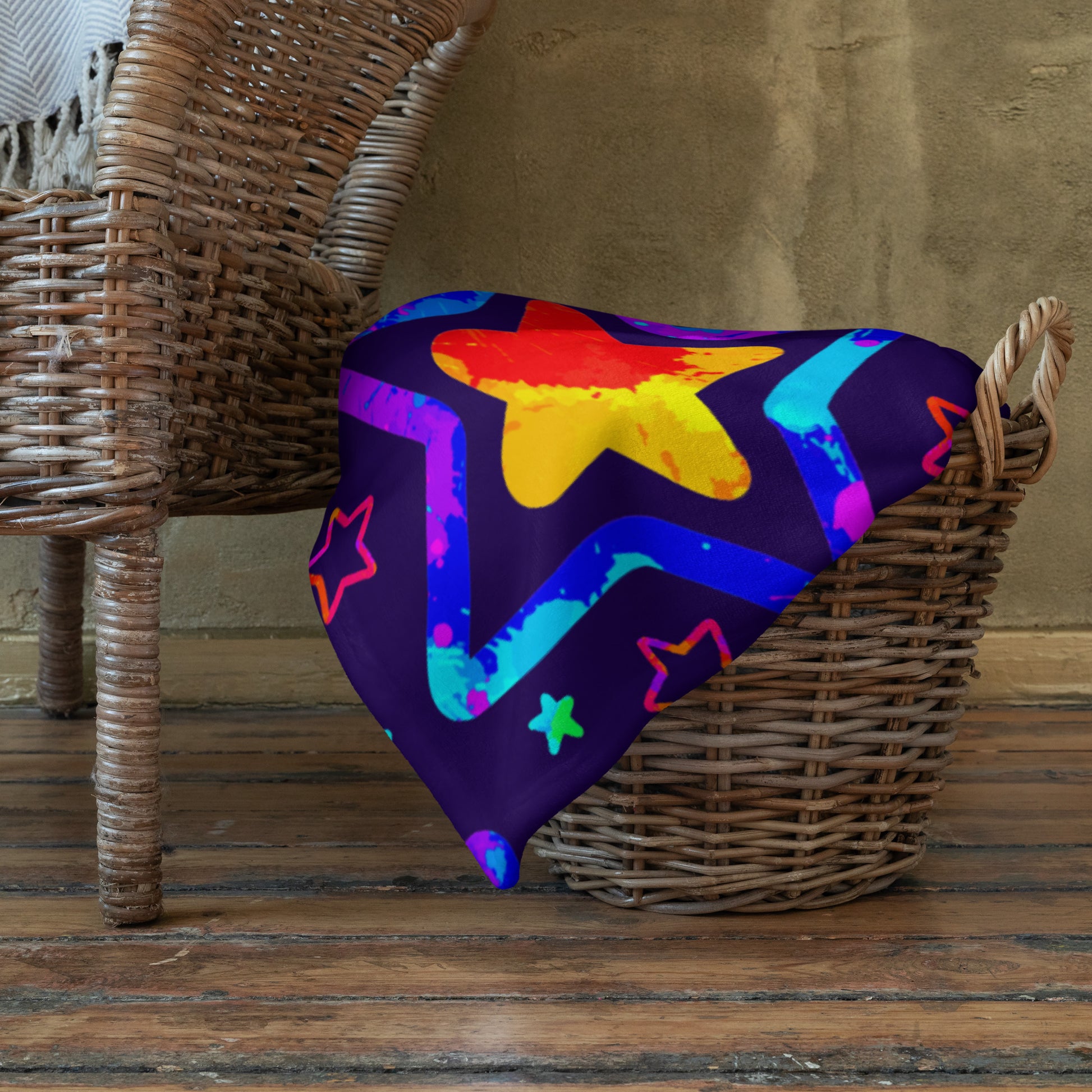 Colorful star-patterned blanket draped over a wicker chair against a wooden floor.